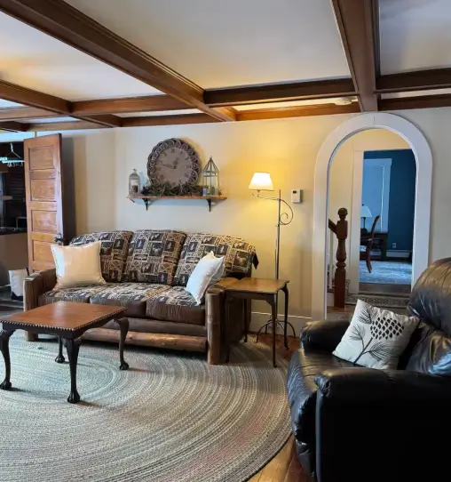 Cozy living area in RiverVail Ranch lodging with rustic furniture, including a patterned sofa, wooden coffee table, and lamp, showcasing a warm and inviting atmosphere for guests.